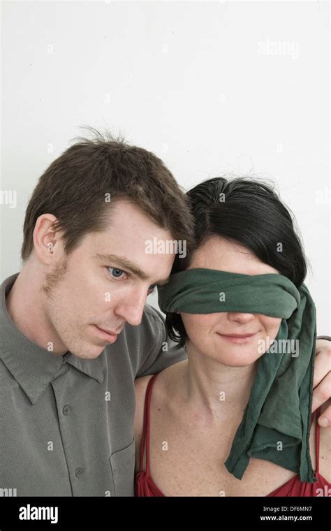 Wife or girlfriend calming down her husband or boyfriend. . Blindfolded wife surprise